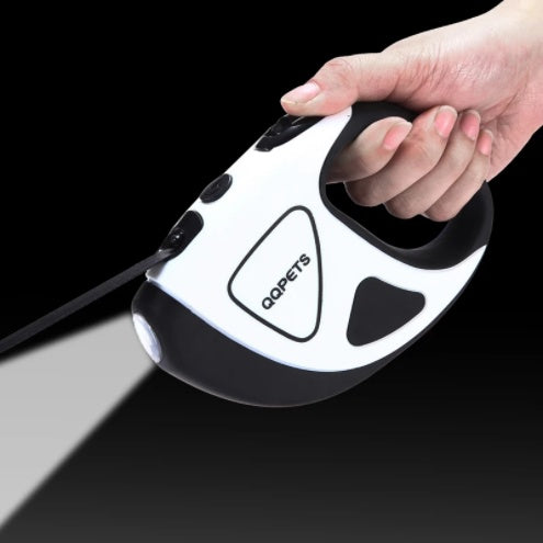 Hand holding automatic retractable LED dog leash with built-in flashlight and ergonomic handle against black background