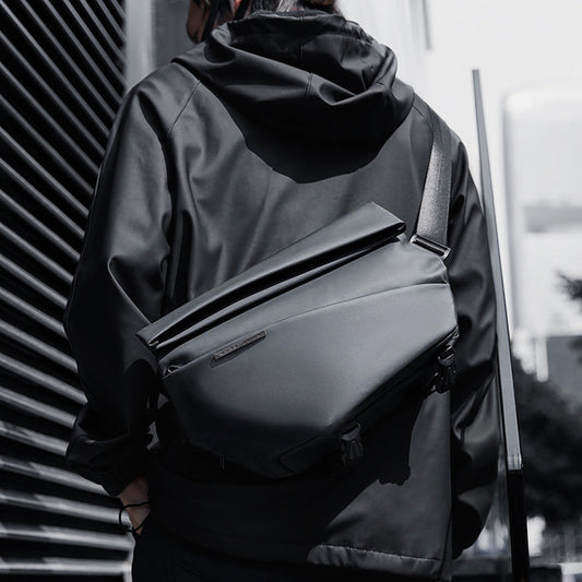Functional men’s messenger bag in black, worn crossbody with adjustable strap, made of water-resistant fabric for cyclists and commuters.